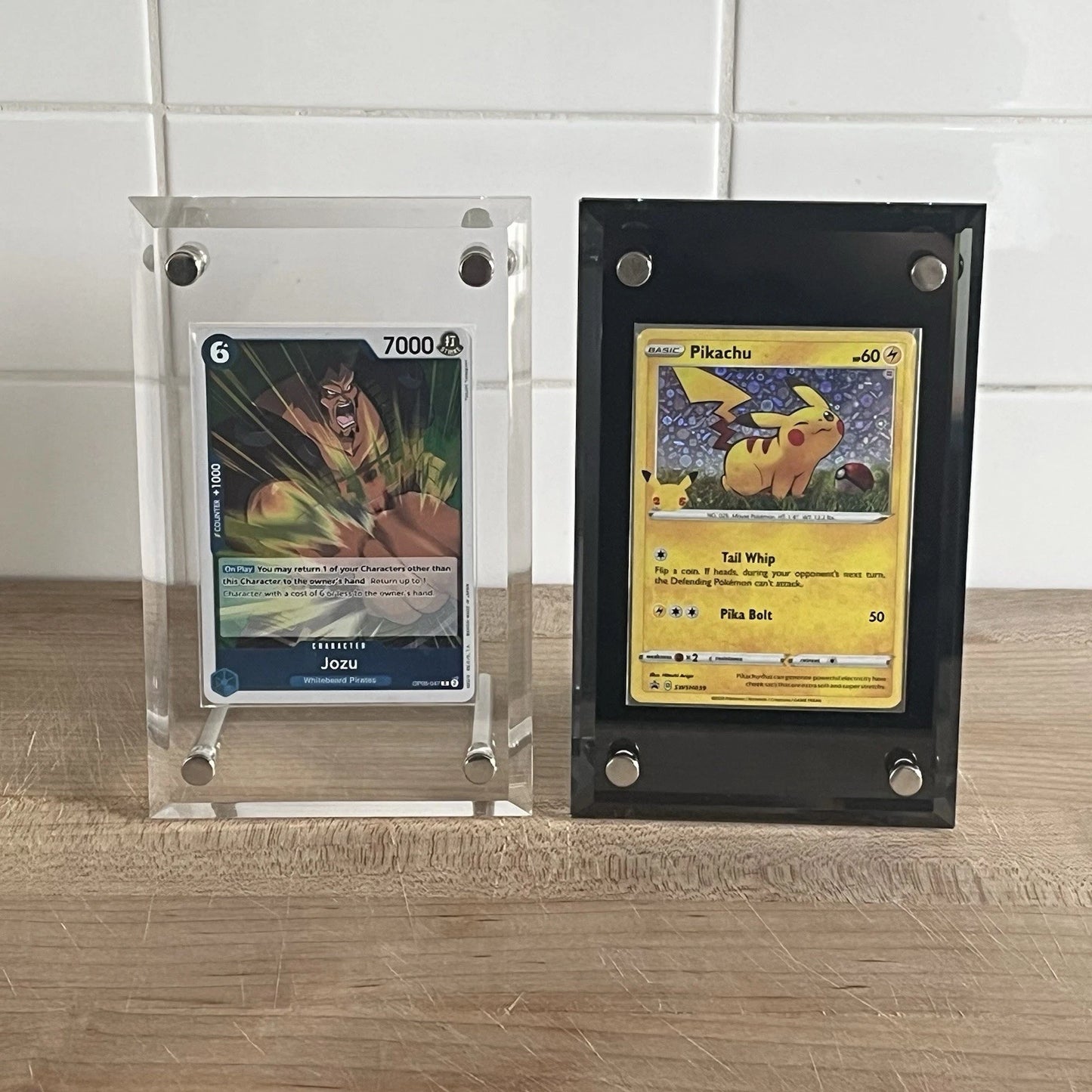 One Piece and Pokemon TCG cards displayed in an acrylic standing screwdown case for standard sized cards in the colors clear and black.