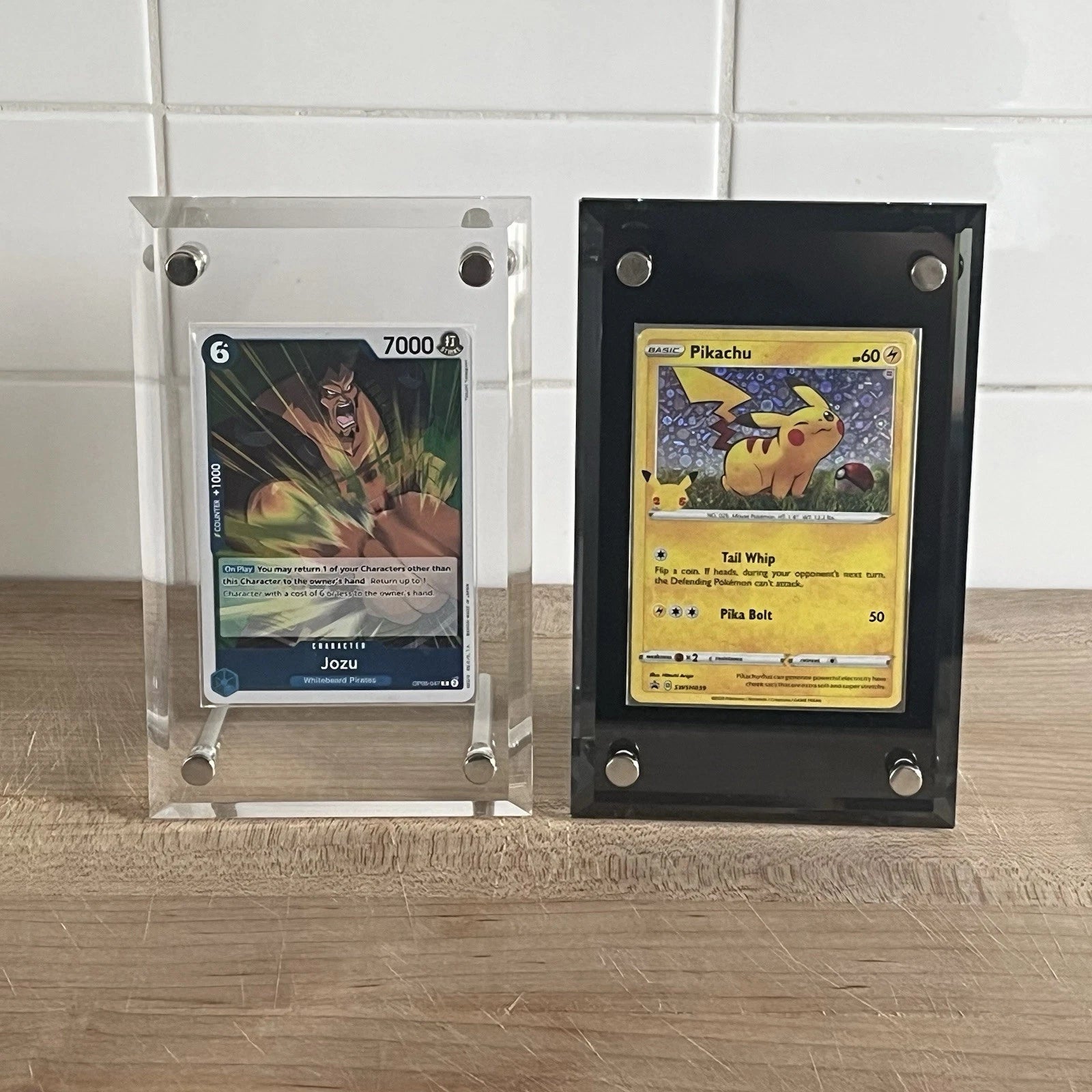 One Piece and Pokemon TCG cards displayed in an acrylic standing screwdown case for standard sized cards in the colors clear and black.