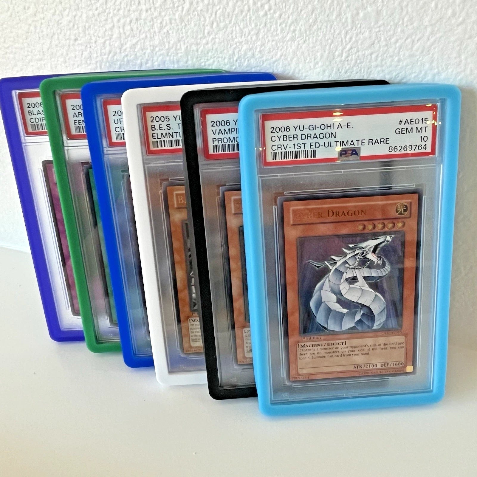 Several PSA Graded Cards on display in PSA Slab bumper guards in a variety of colors.
