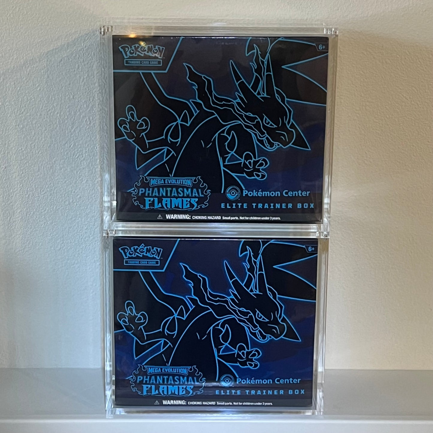 Two Pokémon Center Phantasmal Flames Elite Trainer Boxes on display in stackable Acrylic Cases.